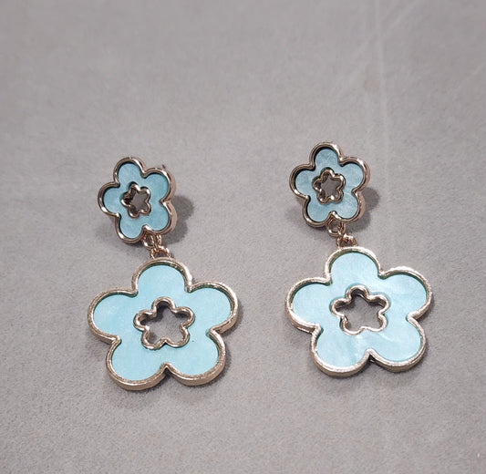 Flower-shaped earrings on a soft Blue background
