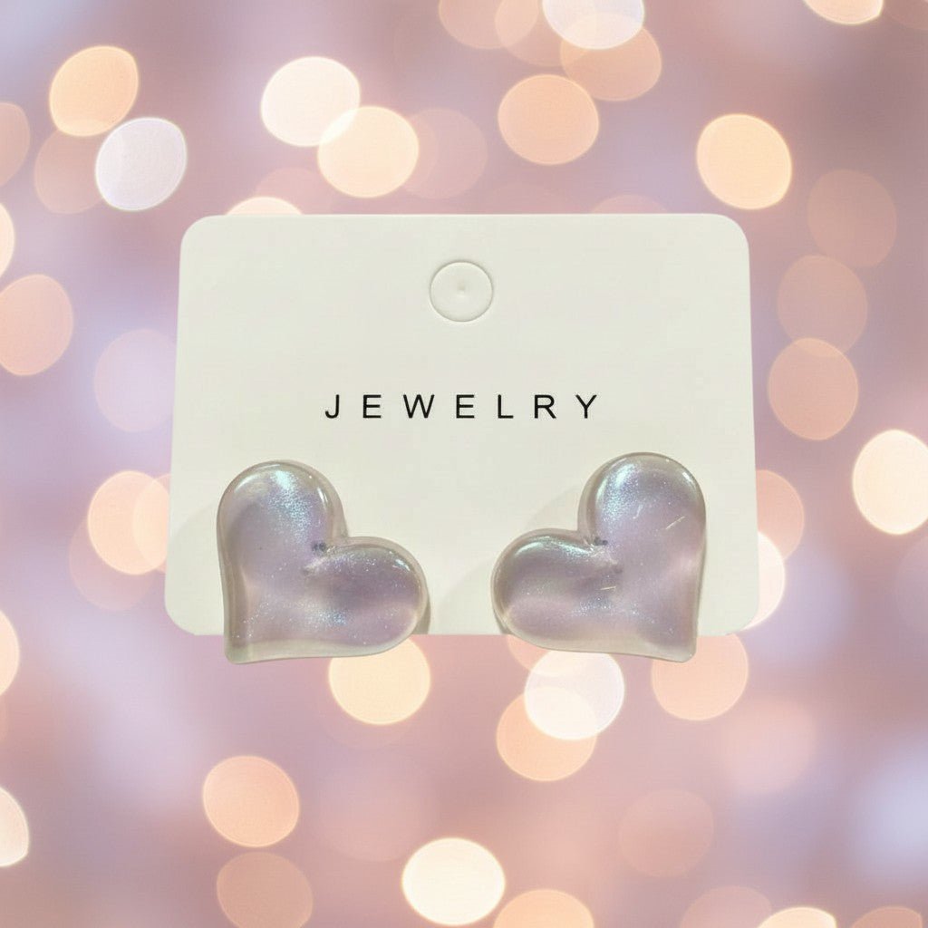 Heart-shaped earrings on a jewelry card with a blurred bokeh background
