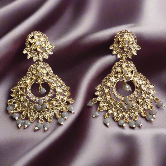 Gold and gray earrings on a gray surface